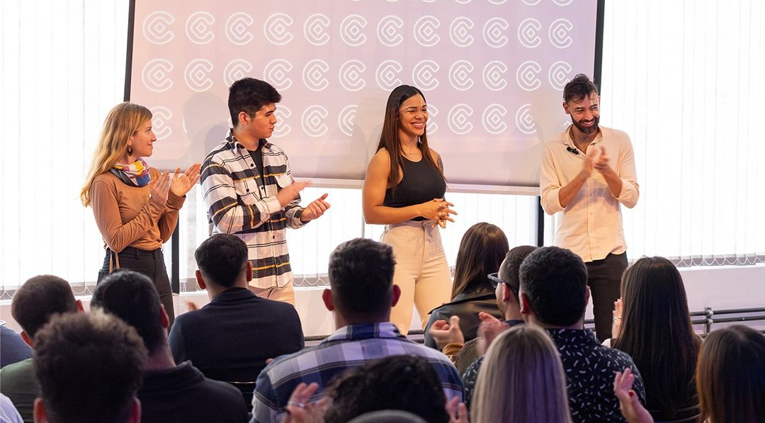 Cuatro personas cierran una charla del ecosistema Campus CO frente al público, que aplaude