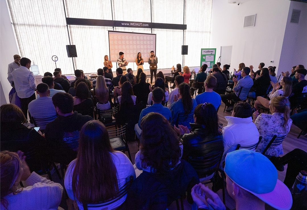 Sala completa durante un encuentro del ecosistema, con el público sentado frente al escenario